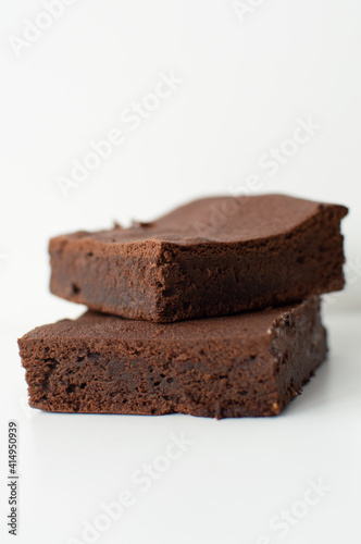 Pieces of fresh home-made brownie on white background. Delicious chocolate pie close-up isolated tasty cake.