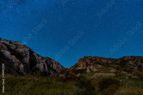 The Szekler Stone (Székelykő, Piatra Secuiului) in Trascaului Mountains at night with beautiful starry sky seen from Rimetea Village in Romania.