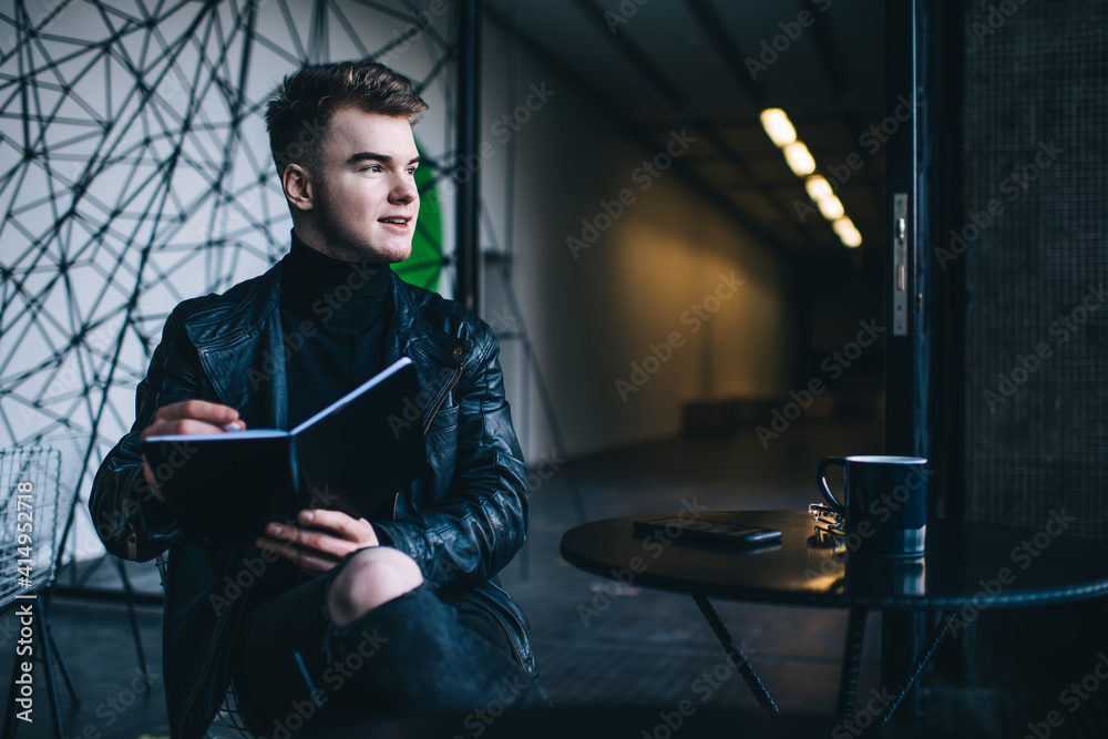 Fototapeta premium Confident guy doing sketch sitting in cafe