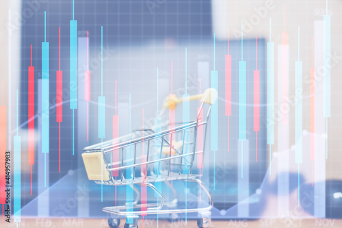 finance graph shows level against background of coins of money and shopping trolley