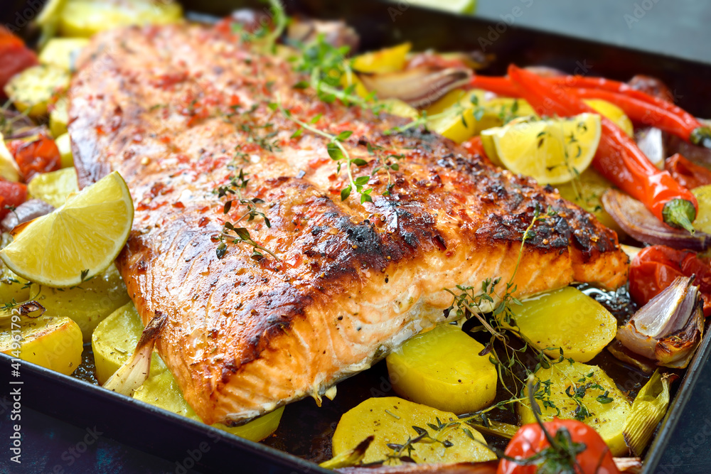 Großes saftiges Lachsfilet mit pikanter Chili-Honig-Marinade, mit Gemüse gebacken und heiß auf dem Backblech serviert - Juicy salmon fillet with a chili honey marinade baked with vegetables Großes saftiges Lachsfilet mit pikanter Chili-Honig-Marinade, mit Gemüse gebacken und heiß auf dem Backblech serviert - Juicy salmon fillet with a chili honey marinade baked with vegetables