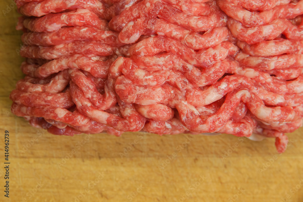 Fresh minced beef on the background of the kitchen board. Empty space for the text Fresh minced beef on the background of the kitchen board. Empty space for the text