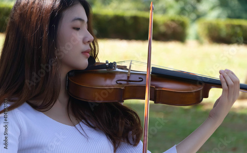 Closeup beautiful lady playing violin with interested feeling