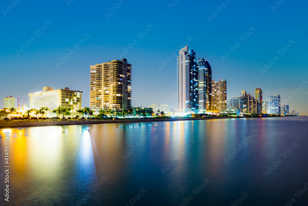 skyline of Miami sunny isles by night with reflections in the water