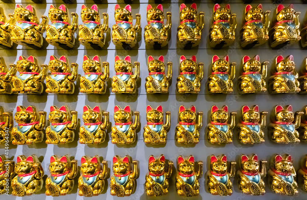 A wall with many Lucky Cats Maneki-Neko front view. A wall with many Lucky Cats Maneki-Neko front view.
