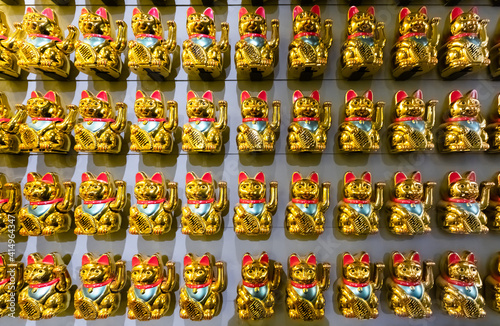 A wall with many Lucky Cats Maneki-Neko front view.