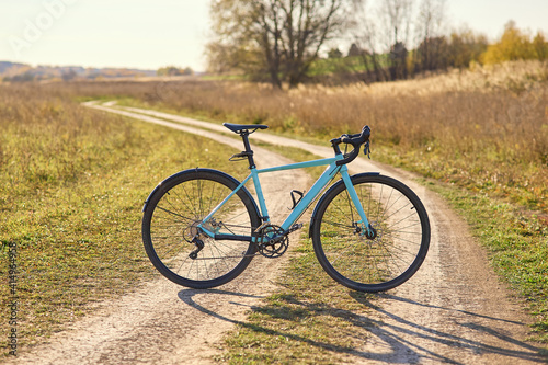 Cyclocross bike on a field, gravel road in sunny, clear weather.