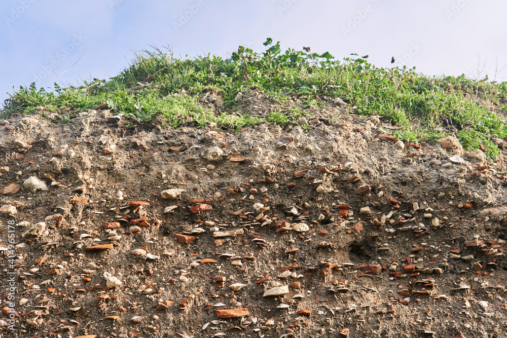 occupation earth - layers of ground with fragments of ancient pottery and shells under the sod layer