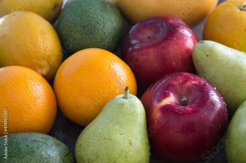 Organic fruits close up photo. Fresh juicy apples and pears on a table. Water drops on fa fruit skin. Healthy eating concept. 