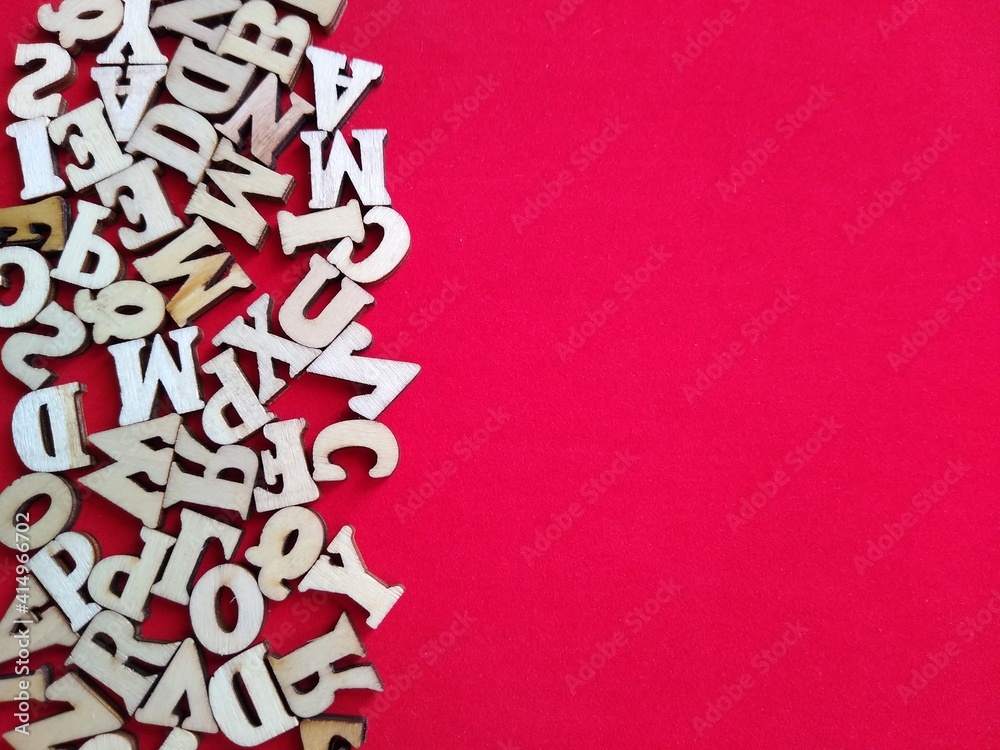 wooden letters of the alphabet scattered on a red background with space for text. High quality photo wooden letters of the alphabet scattered on a red background with space for text. High quality photo