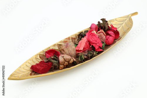 Potpourri on brass leaf isolated on white background.