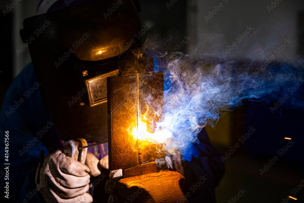 Welder is assembling the workpiece by process shielded metal arc