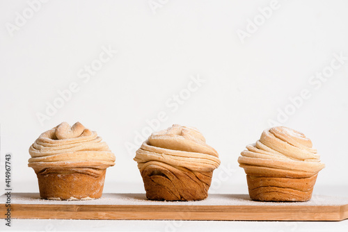 cruffins easter spring pastries, a mix of muffin and croissant on a light background, close-up for text place