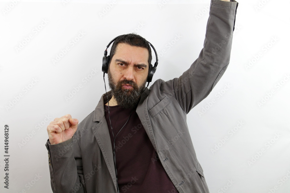 Man with beard wearing casual clothes dancing and listening to music using headphones Man with beard wearing casual clothes dancing and listening to music using headphones