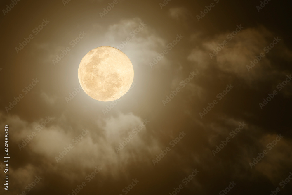 full moon shining through thick clouds