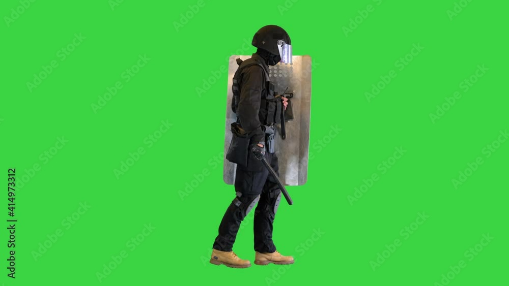 Heavily armored policeman with a shield and a baton walking on a Green Screen, Chroma Key. Heavily armored policeman with a shield and a baton walking on a Green Screen, Chroma Key.