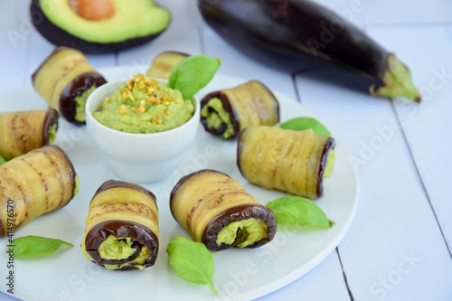 Eggplant rolls. Aubergine rolled with avocado basil sauce and pistachios
