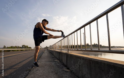 Fototapeta Naklejka Na Ścianę i Meble -  Man stretches the body before running. Fitness, jogging, running, exercise, lifestyle and healthy concept.
