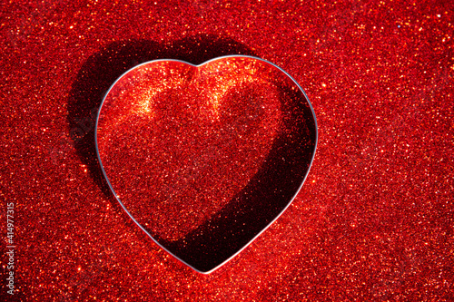 Heart shaped stainless steel on red carborundum background, Valentine day background, Wallpaper and background. photo