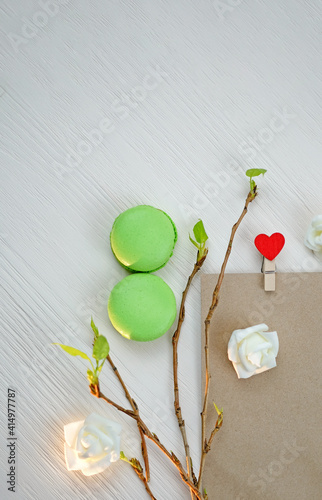 8 March macaroons, envelope, and fresh leaves. Sprig concept, International Womens Day celebrate. Vertical phopto. photo