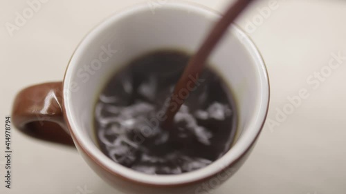 Hot black coffee pouring in a cup. Traditional beverage for breakfast or break. Relaxation moment at restaurant, at work, at bar or at home. Closeup view