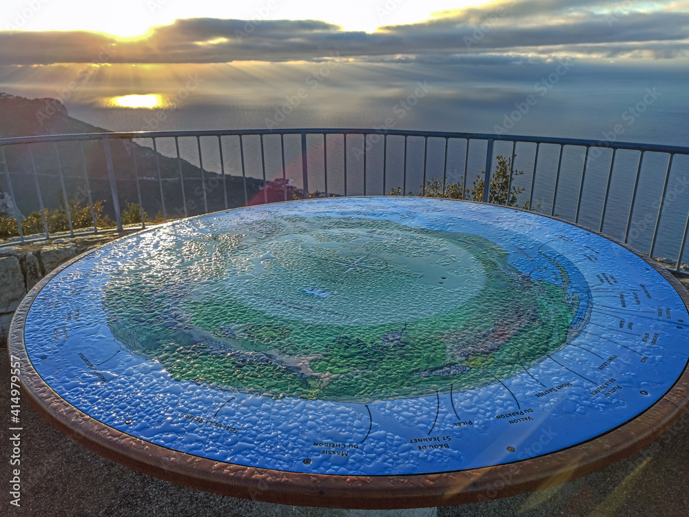 Naklejka premium Table d'orientation recouverte de rosée dans les lueurs du soleil levant en montagne