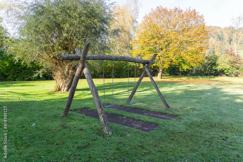 children playground with wooden swing, the seats are made of green plastic, the steel chains hold a lot of weight, without children or people, children's playgrounds empty because of coronavirus children playground with wooden swing, the seats are made of green plastic, the steel chains hold a lot of weight, without children or people, children's playgrounds empty because of coronavirus