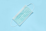 Surgical face mask on blue background protection against COVID-19 coronavirus. Healthcare and medical concept
