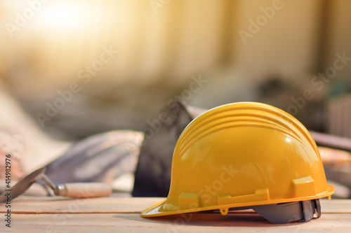 Yellow helmet hard hat on wood floor in constriction site