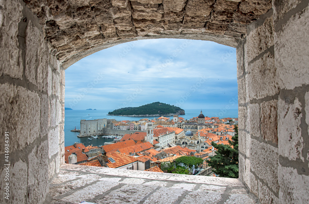 View from stone window of red rooftops and fortress