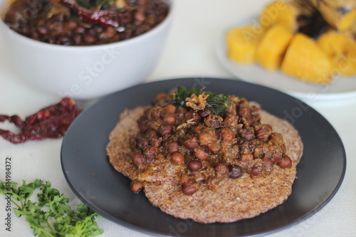 Home made Finger millet pancakes served with black chickpea gravy and steamed plantain photo