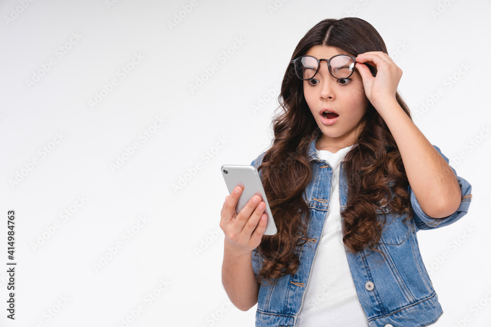 Shocked young caucasian girl using her smart phone isolated over white background Shocked young caucasian girl using her smart phone isolated over white background