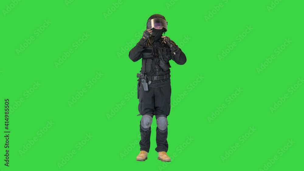 Special police unit taking helmet off on a Green Screen, Chroma Key.