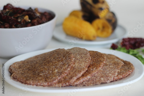 Home made Finger millet pancakes served with black chickpea gravy and steamed plantain photo