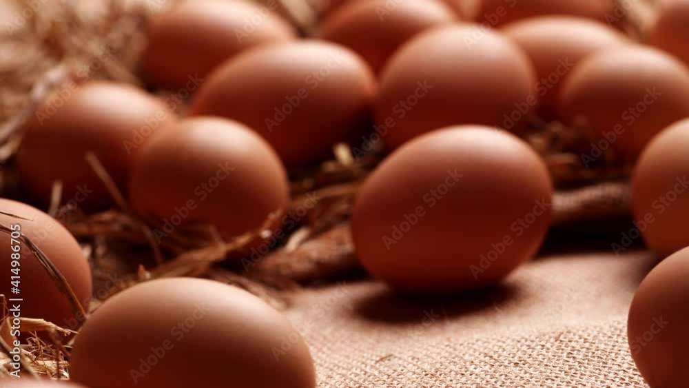 Dolly shot brown eggs on natural burlap. Camera moving forward through fresh chicken eggs. Dolly shot brown eggs on natural burlap. Camera moving forward through fresh chicken eggs.