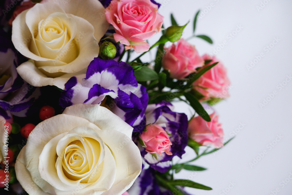 Background. Bouquet of flowers close-up on a white background. White and pink roses, blue-white eustoma. Place for text.