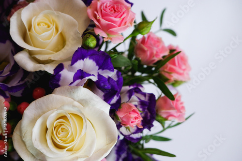 Background. Bouquet of flowers close-up on a white background. White and pink roses, blue-white eustoma. Place for text. © Trik