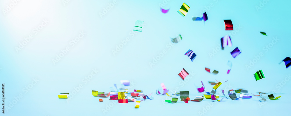 falling multicolored confetti on a light blue background. holiday background falling multicolored confetti on a light blue background. holiday background