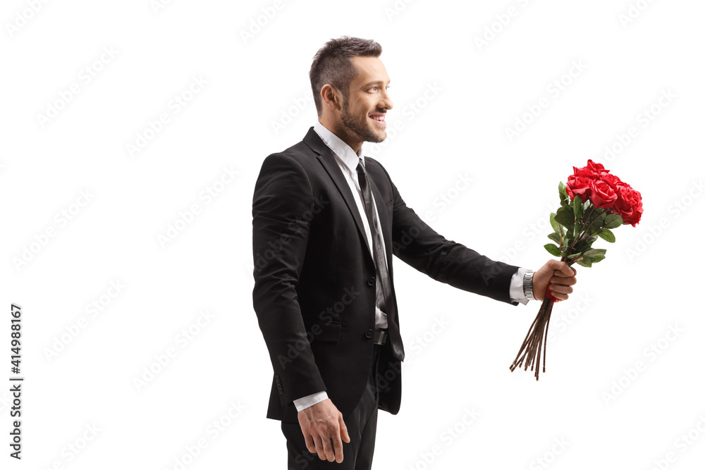 Romantic man smiling and giving a bunch of red roses Romantic man smiling and giving a bunch of red roses