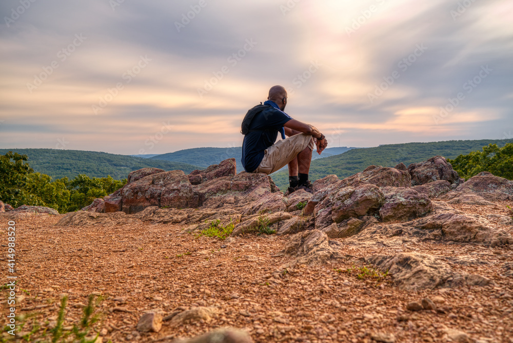 Man enjoying the view at the top of a mountain during a hike of Taum Sauk Mountian, the highest elevation point in Missouri.