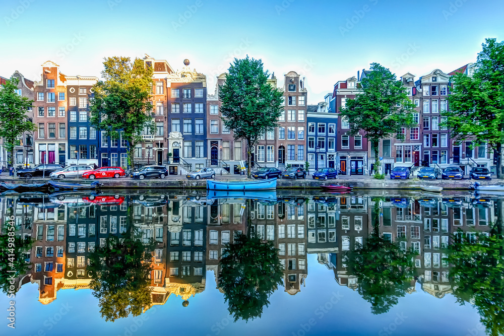 Reflections of iconic buildings along an Amsterdam canal