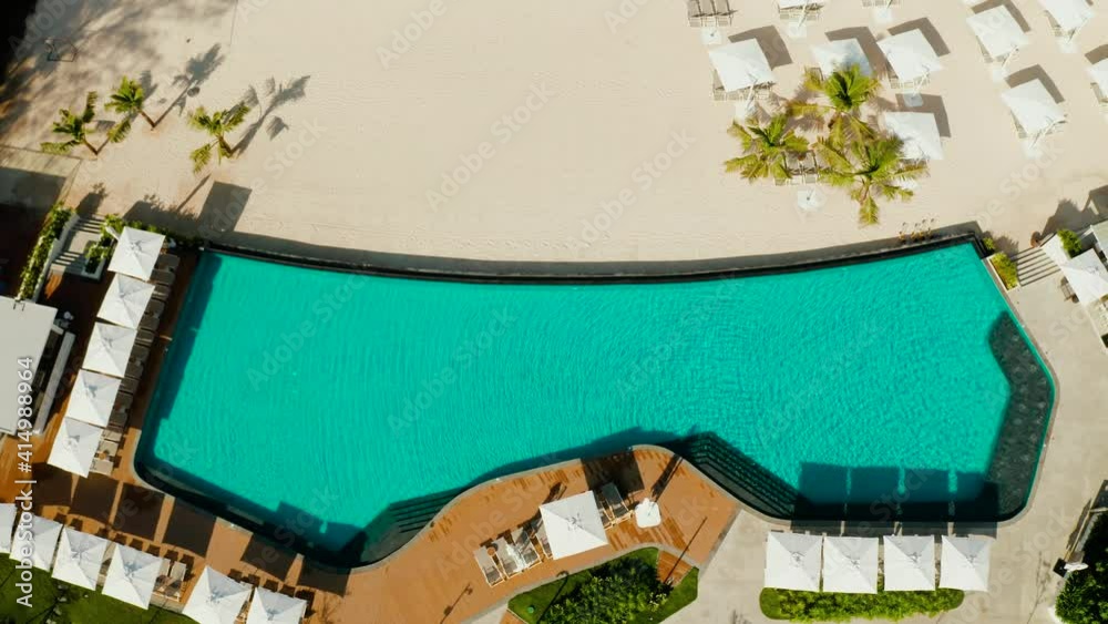 Luxury Resort Pool, top view. Swimming pool with umbrellas and sun beds on the sandy beach , aerial view. Summer and travel vacation concept Luxury Resort Pool, top view. Swimming pool with umbrellas and sun beds on the sandy beach , aerial view. Summer and travel vacation concept
