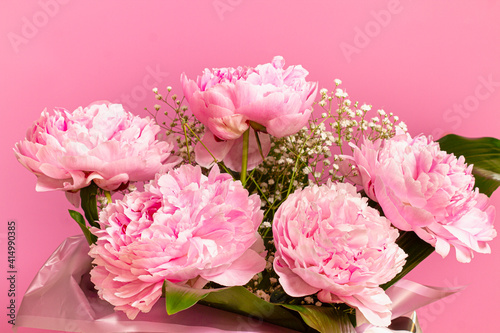 Beautiful bouquet of pink peonies on a pink background.