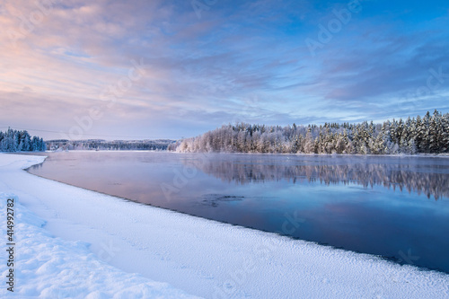River Pielisjoki flowing through frozen winter landscape, Eastern Finland.