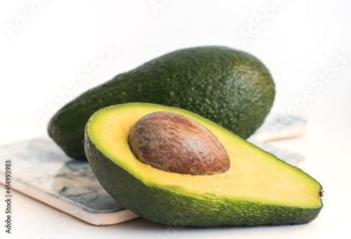 green delicious avocado cut lengthwise with a bone