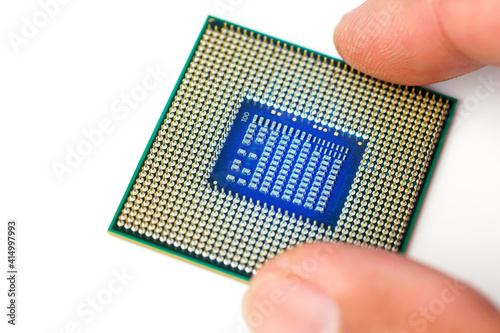 Obraz na płótnie Man hand holding CPU, processor close-up for PC computer and notebook, separate CPU macro image on white background, electrical circuit. 