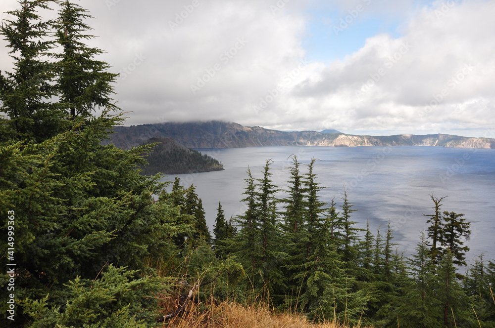 Scenic view of  Crater Lake National Park, with trees in front and part of Wizard Island