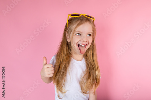Wallpaper Mural Child in sunglasses showing tongue showing cool on pink background