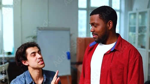 italian or indian teacher practicing vocal cords with african american man in class day time