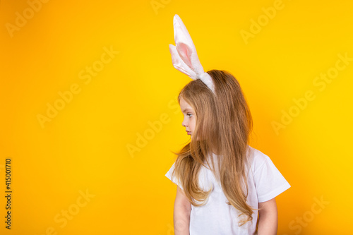 Baby Easter bunny turned to the side on a yellow background